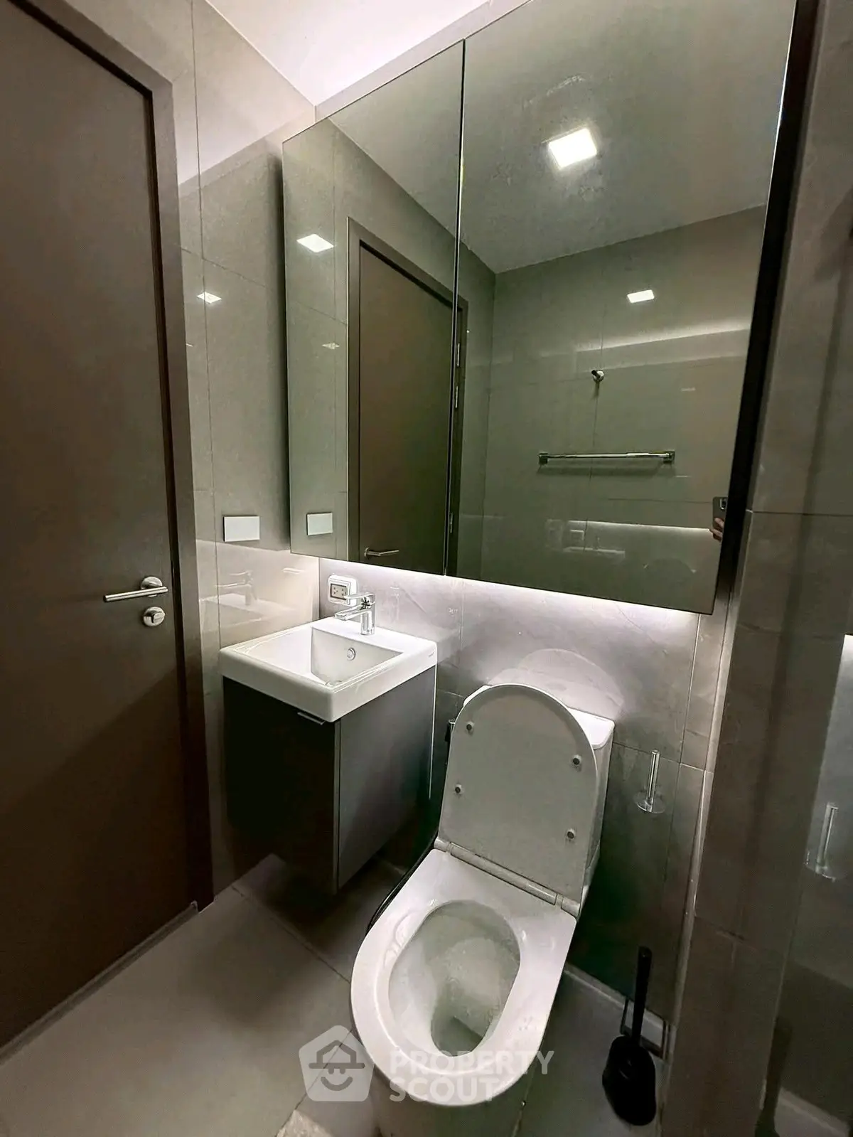 Modern bathroom with sleek fixtures and mirrored cabinet in a contemporary apartment.
