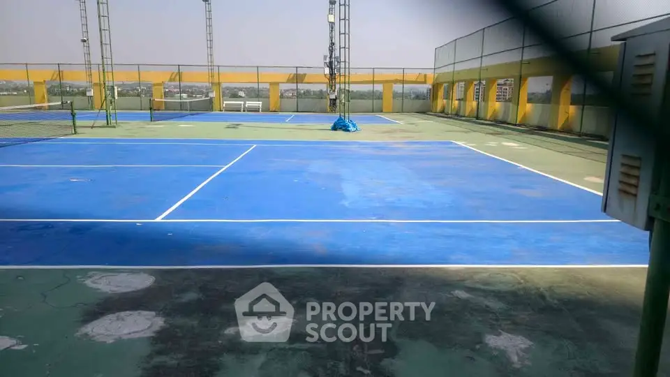 Spacious rooftop tennis court with panoramic city views, perfect for sports enthusiasts seeking luxury amenities.
