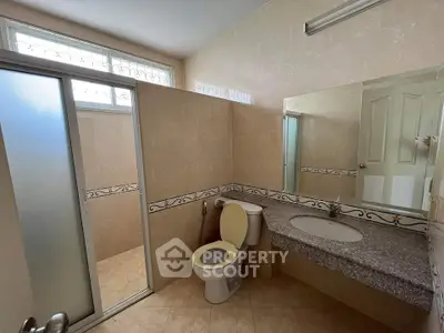 Spacious bathroom with modern fixtures and frosted glass shower door