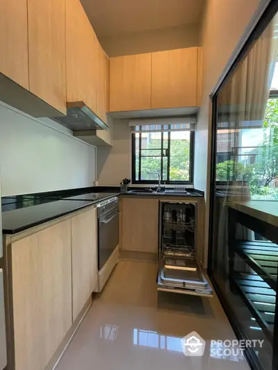 Modern kitchen with sleek cabinetry and built-in dishwasher in a stylish apartment.