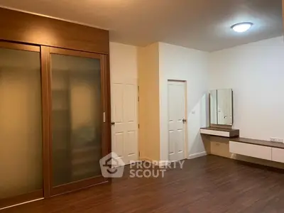 Spacious bedroom with wooden flooring and built-in wardrobe