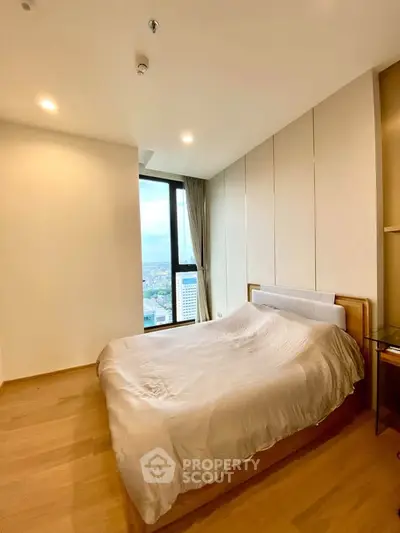 Spacious bedroom with city view in modern high-rise apartment