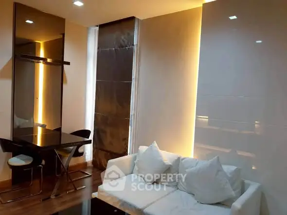 Modern living room with sleek design, featuring a cozy white sofa and stylish dining area.