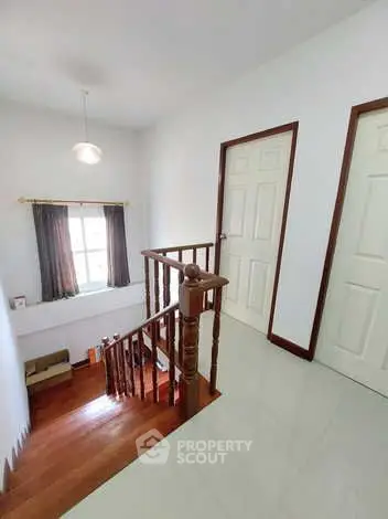 Bright hallway with wooden staircase and natural light from window