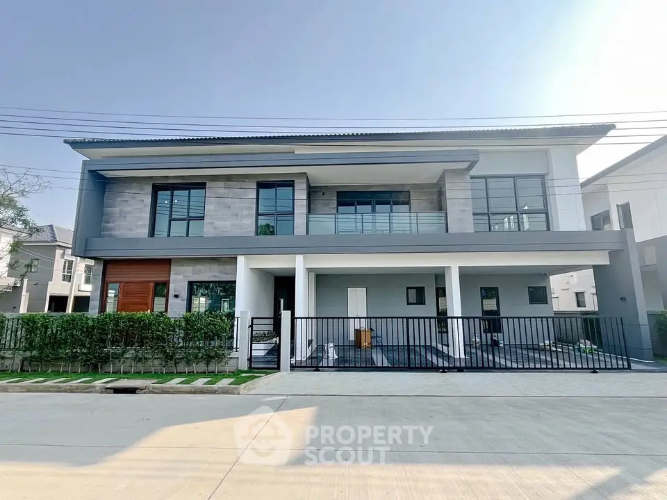 Modern two-story house with sleek design and spacious balcony in a suburban neighborhood.