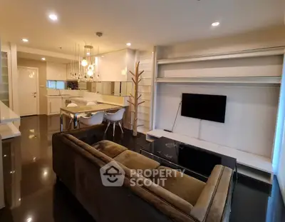 Modern open-layout living room with sleek kitchen and stylish lighting