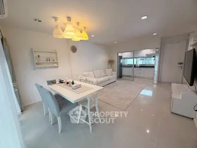 Spacious modern living room with open kitchen and elegant dining area, perfect for family gatherings.