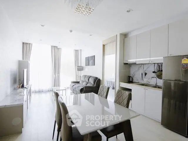 Modern open-layout living room and kitchen with elegant dining area and natural light.