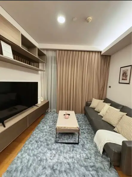 Modern living room with cozy sofa, large TV, and elegant decor.