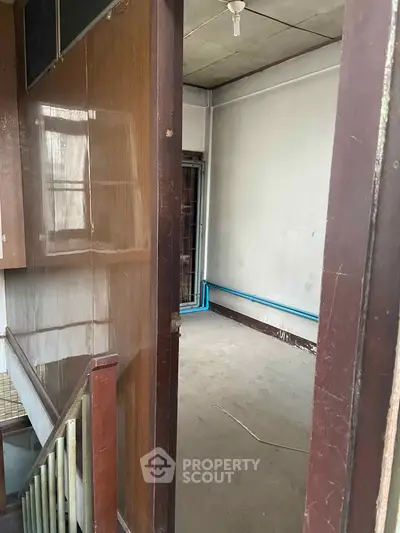 Spacious interior with potential for renovation, featuring wooden paneling and natural light.