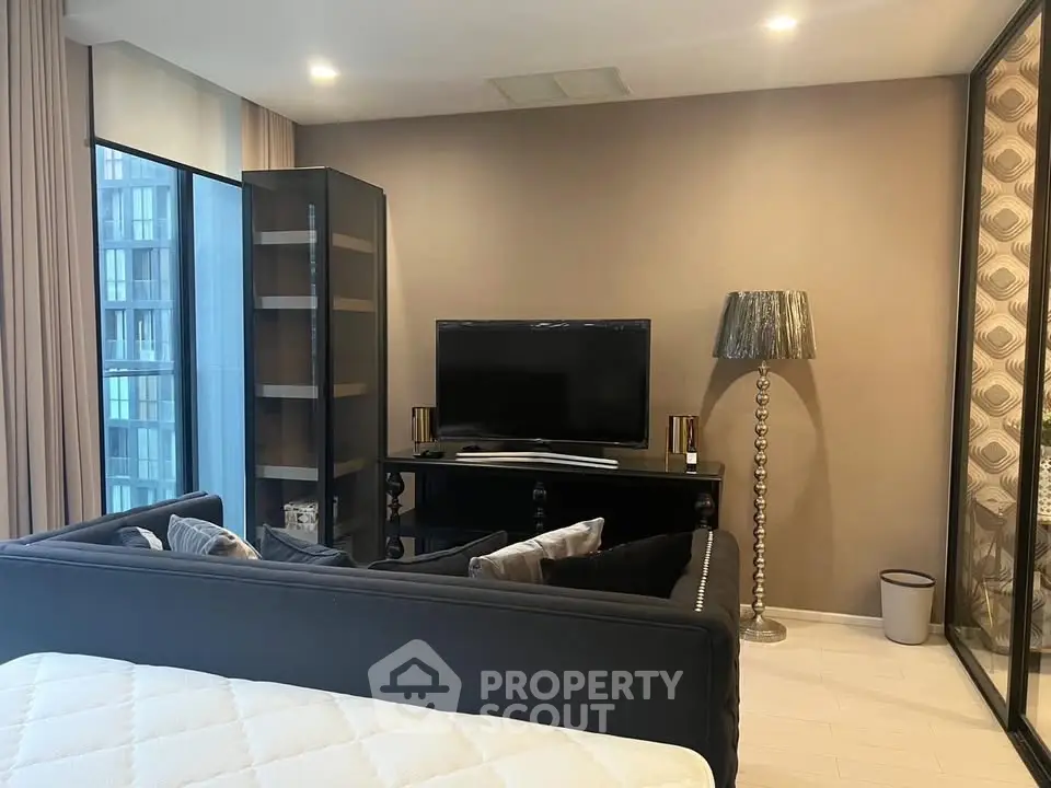 Modern living room with sleek furniture and large TV in a stylish apartment.
