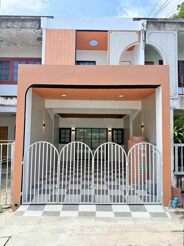 Modern townhouse exterior with unique geometric design and gated entrance.