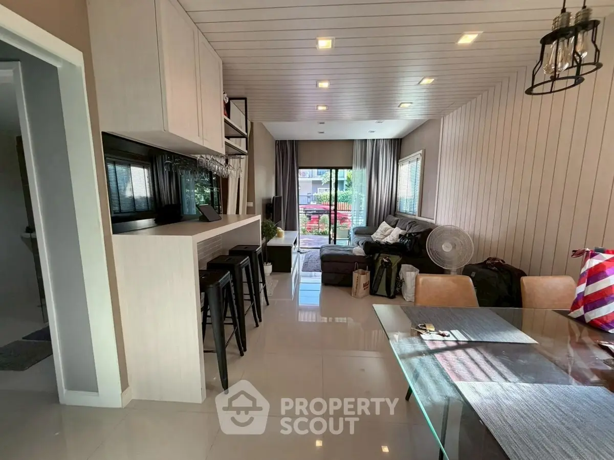 Modern living room with open layout and stylish decor, featuring a cozy seating area and dining space.