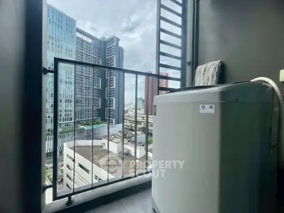 Modern high-rise balcony with city view and washing machine, perfect for urban living.