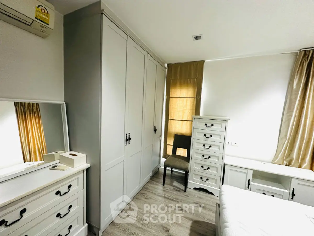 Bright and cozy bedroom with elegant white furniture and natural light.