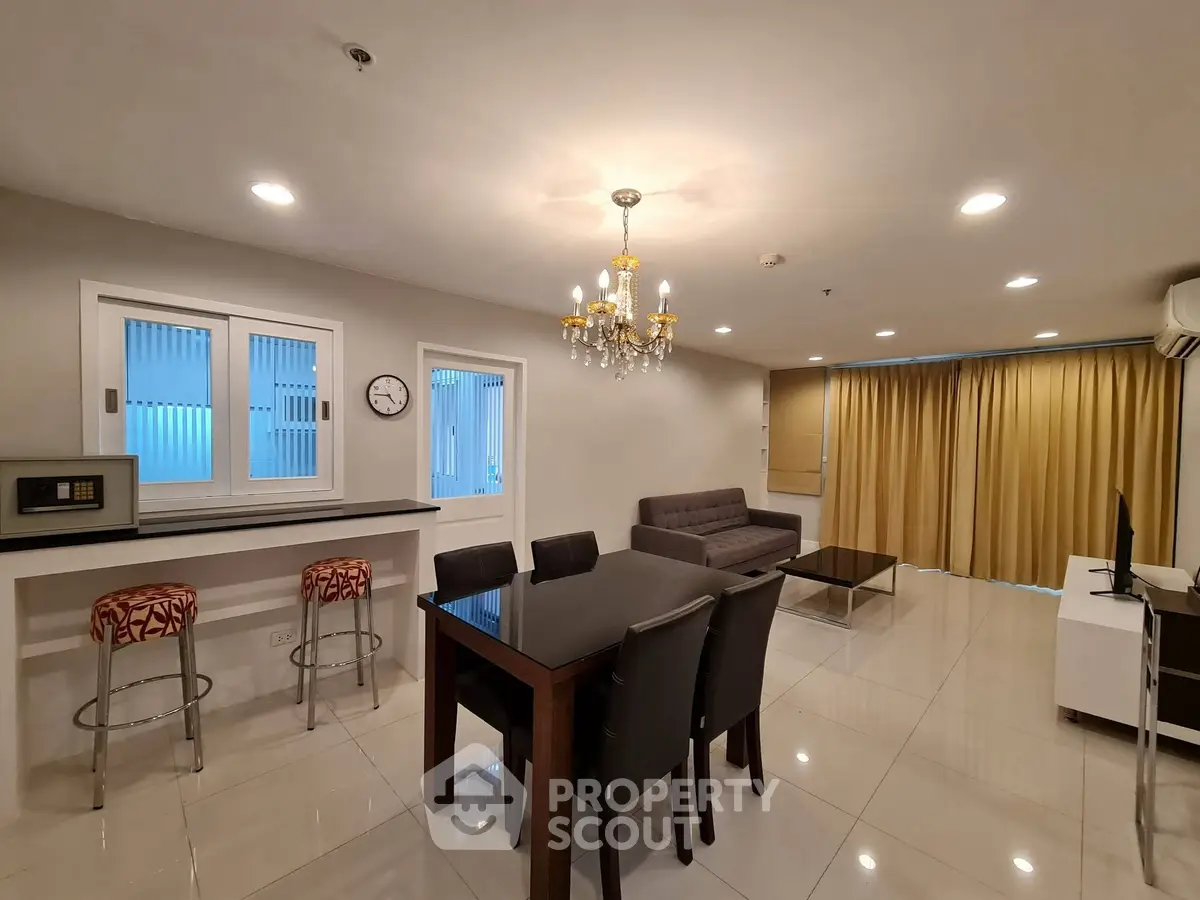 Spacious modern living room with elegant chandelier and open kitchen layout