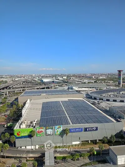 Expansive rooftop view of a commercial building with solar panels and cityscape backdrop.