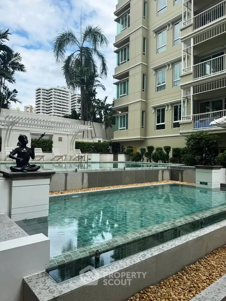 Luxurious apartment building with serene pool and lush greenery