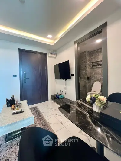 Modern living room with marble table and wall-mounted TV, elegant interior design.