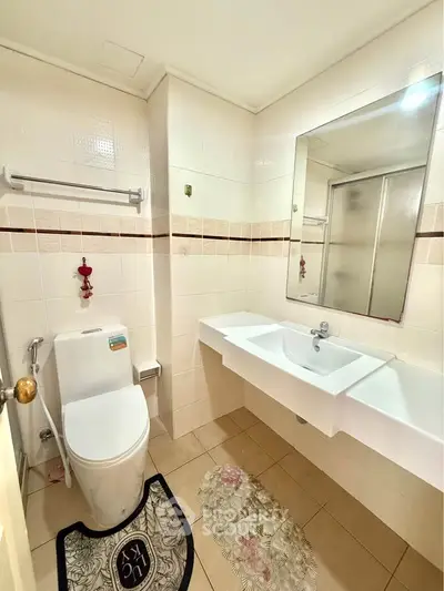 Modern bathroom with sleek fixtures and large mirror, perfect for a contemporary home.
