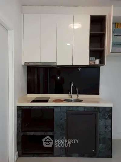 Modern compact kitchen with sleek cabinetry and integrated appliances in a stylish apartment.