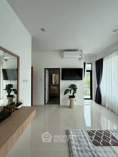Modern living room with sleek decor and large windows offering natural light.