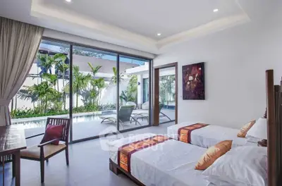 Luxurious bedroom with pool view and modern decor in tropical villa