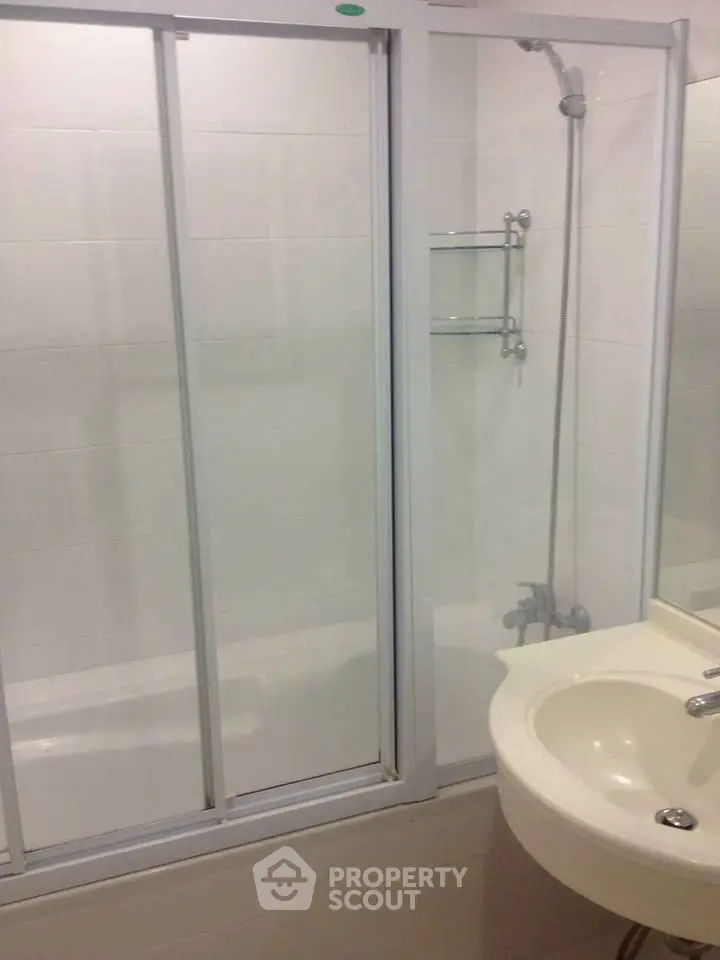Modern bathroom with sleek shower enclosure and elegant sink design.