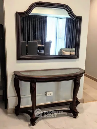 Elegant interior with classic wooden console table and mirror, perfect for stylish home decor.