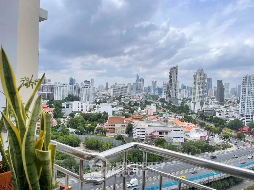 Stunning cityscape view from a high-rise balcony with lush greenery and skyline.