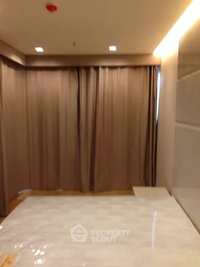 Spacious bedroom with elegant curtains and modern lighting