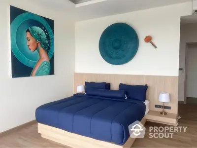 Modern bedroom with stylish decor and blue bedding in a contemporary apartment.