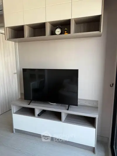 Modern living room with sleek TV stand and wall-mounted storage cabinets.