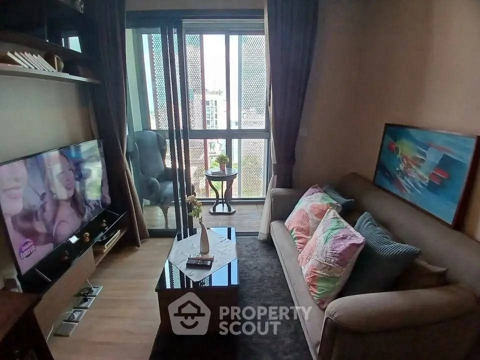 Cozy living room with balcony view, modern decor, and natural light.