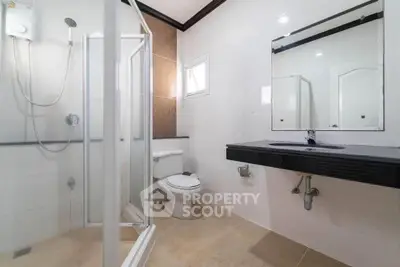 Modern bathroom with glass shower and sleek black countertop