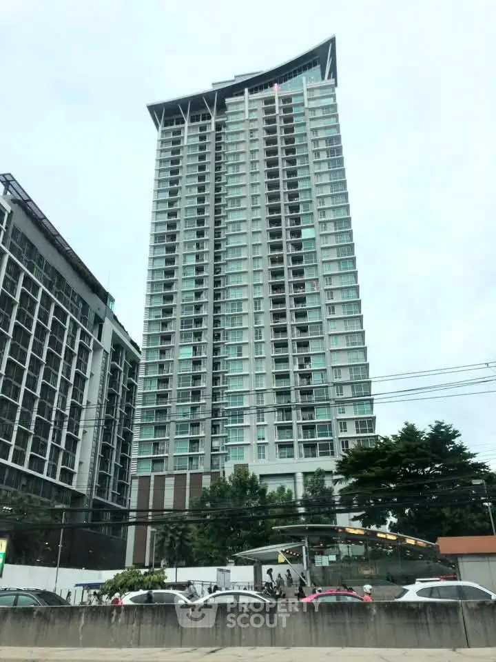 Modern high-rise residential building with sleek design and large windows in urban setting.