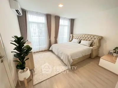 Spacious and elegant bedroom with plush bed and natural light