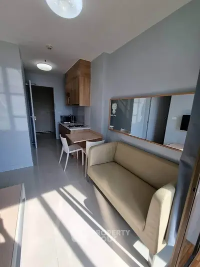 Modern apartment interior with compact kitchen and cozy living area, perfect for urban living.