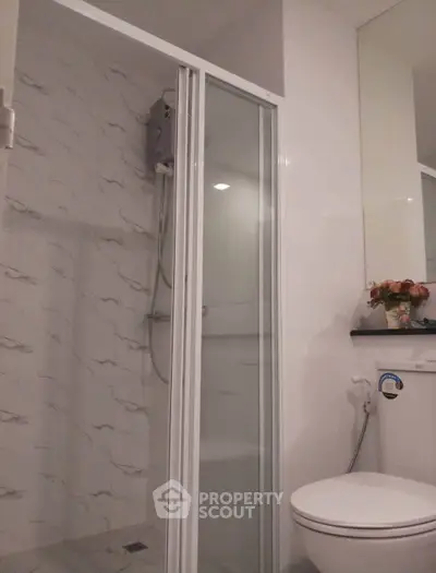 Modern bathroom with glass shower and sleek white fixtures