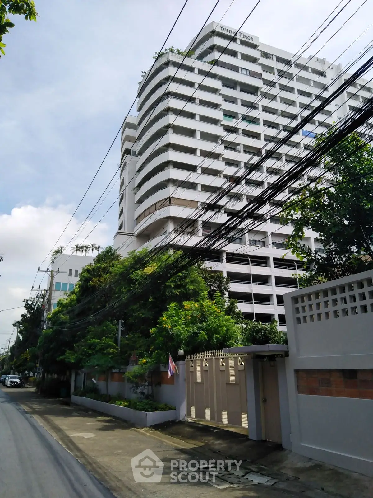 Modern high-rise building with lush greenery and clear blue sky