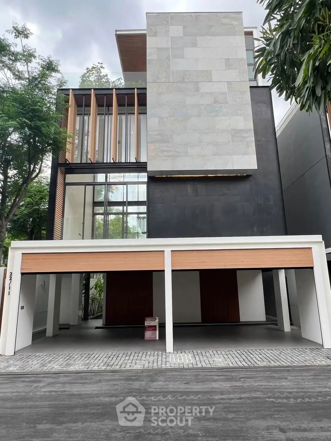 Modern three-story building with sleek facade and spacious garage, ideal for luxury urban living.