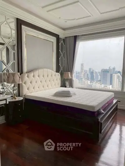 Luxurious bedroom with city view, elegant decor, and large windows in high-rise apartment.