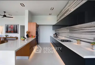 Modern kitchen with sleek black cabinets and marble backsplash, featuring an open layout and gas stove.