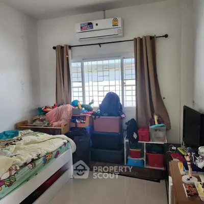 Cozy bedroom with air conditioning and natural light, ideal for comfortable living.