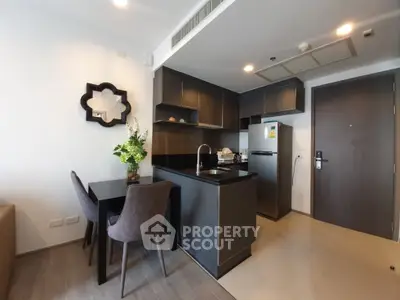 Modern kitchen with sleek black cabinets and dining area in stylish apartment