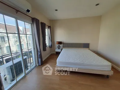 Spacious bedroom with large windows and balcony access in modern apartment