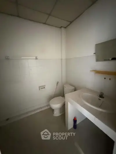 Simple bathroom with white tiles and basic fixtures, ideal for minimalist living.
