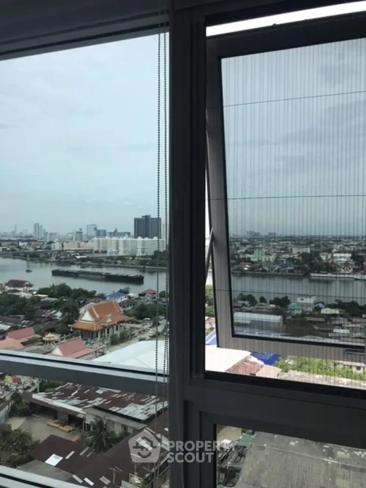 Stunning high-rise city view from a modern apartment window, showcasing urban skyline and river.