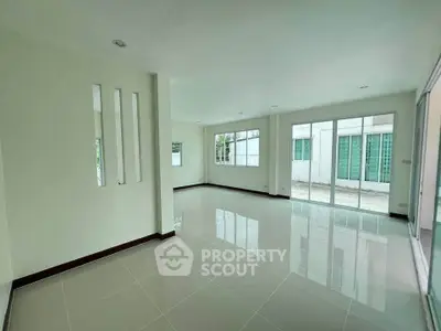 Spacious modern living room with large windows and glossy tiled floors