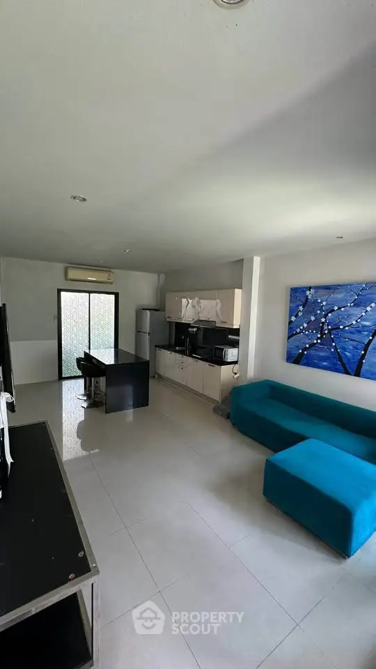 Modern living room with sleek furniture and vibrant artwork, featuring an open layout and contemporary design.